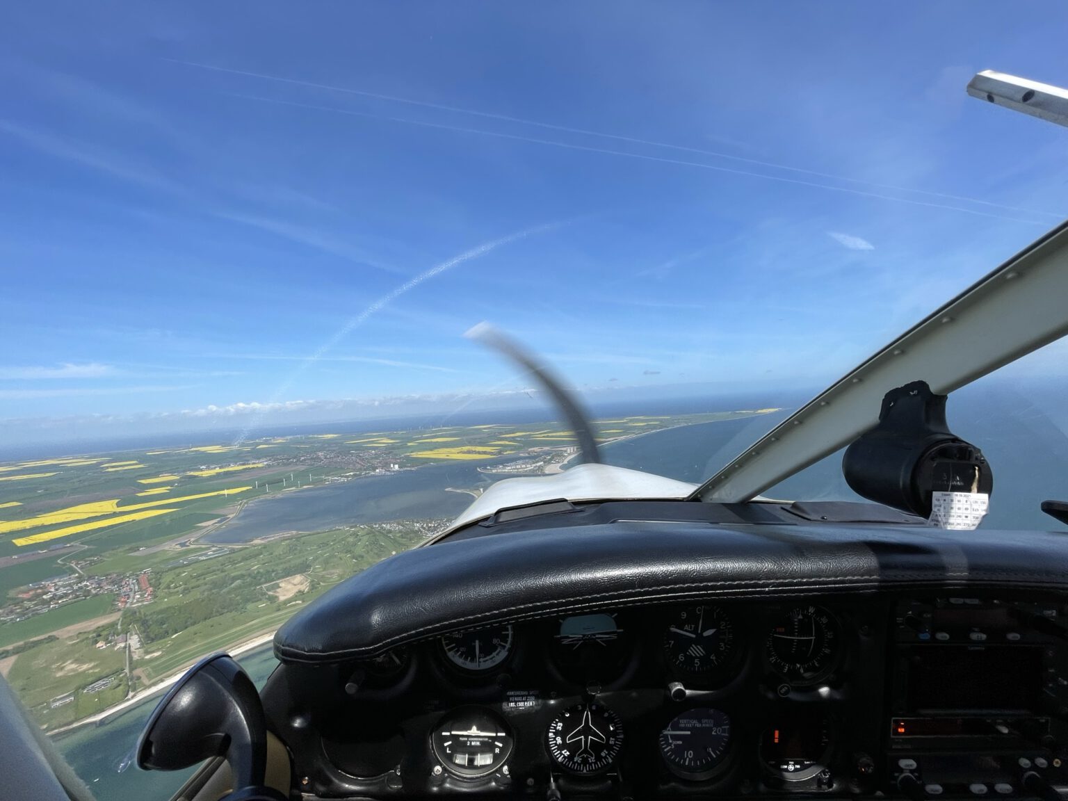 Blick aus dem Cockpit einer PA28 auf einem Rundflug über die Lübecker Bucht. Das Erlebnis fliegt gerade über Fehmarn.